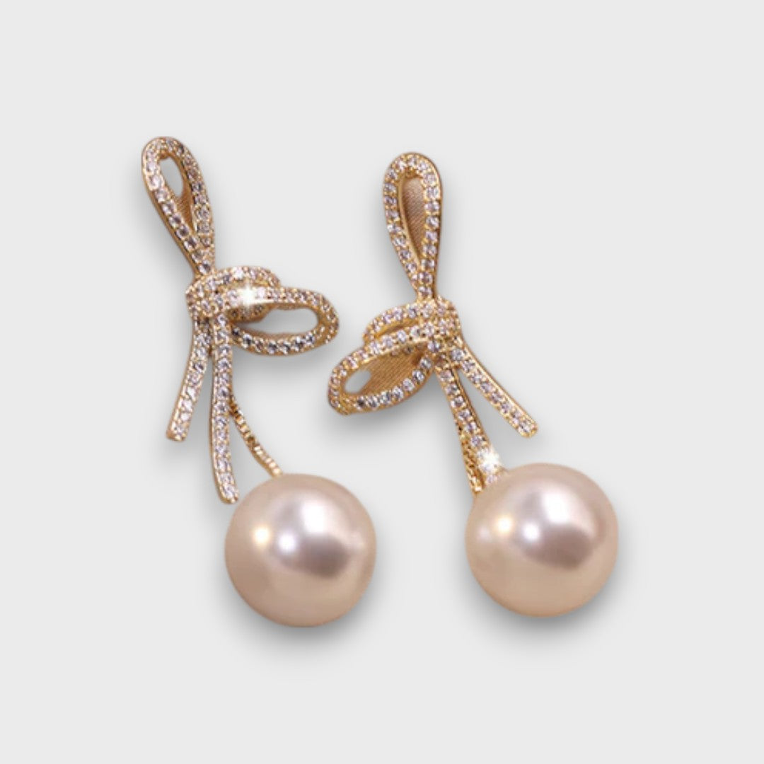 Celinea – Goldene Schleifenohrringe mit leuchtender Perle